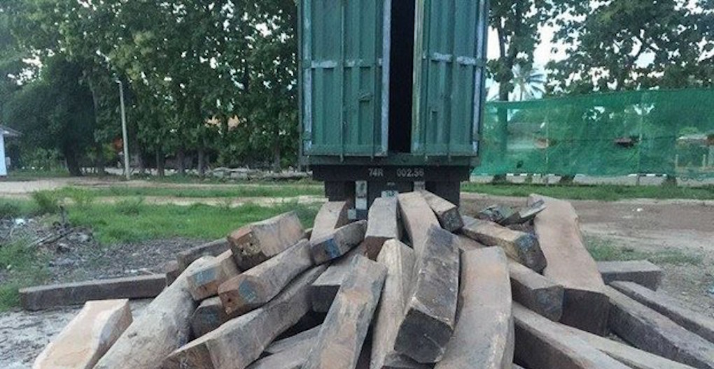 Officials unload illegal timber from a truck at the Attapeu Industry and Commerce Department.